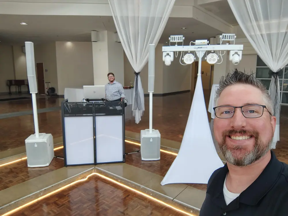 DJ selfie in front of booth smiling