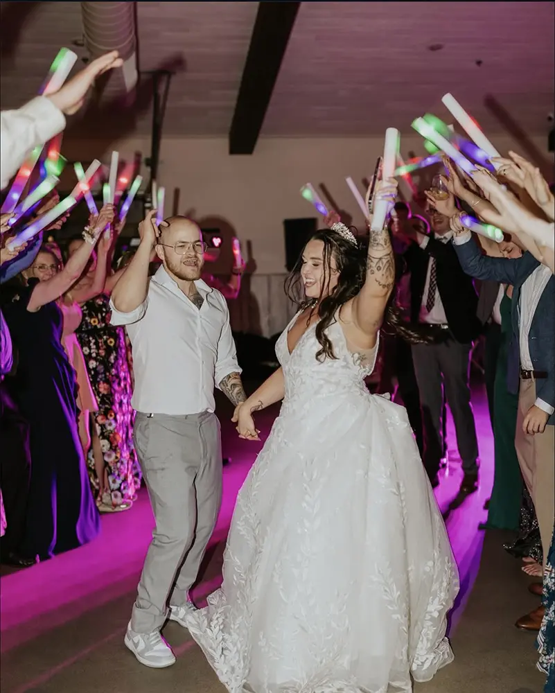 bride and groom dancing under arch of wedding guests' holding lights